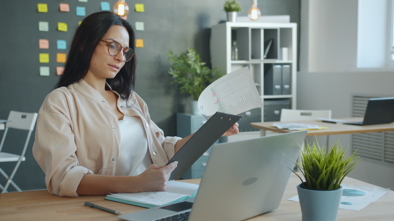 Owner reviewing documents and a laptop at a desk.