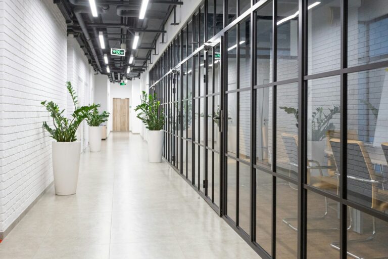 Clean commercial office corridor with glass walls.
