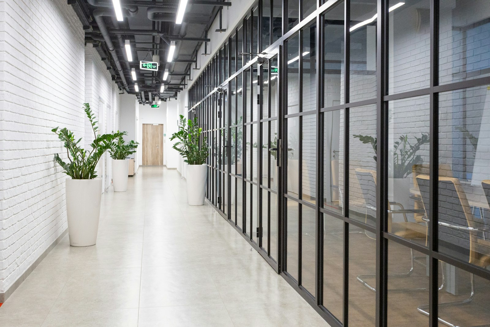 Clean commercial office corridor with glass walls.