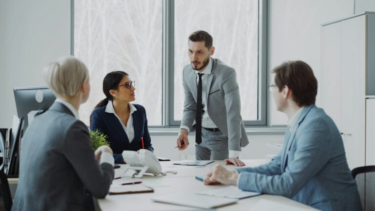 Business team discussing reports around a conference table in a modern office