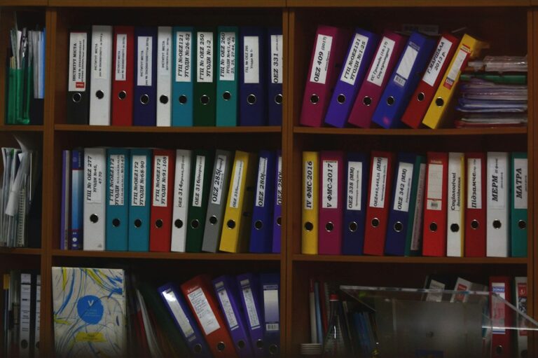 Colorful ring binders organized on shelves as a clean source of truth