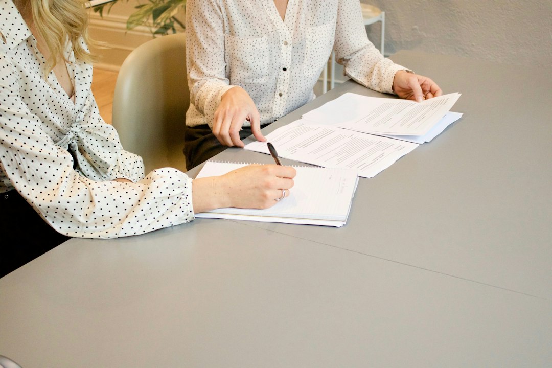 Two people signing financing documents at a desk